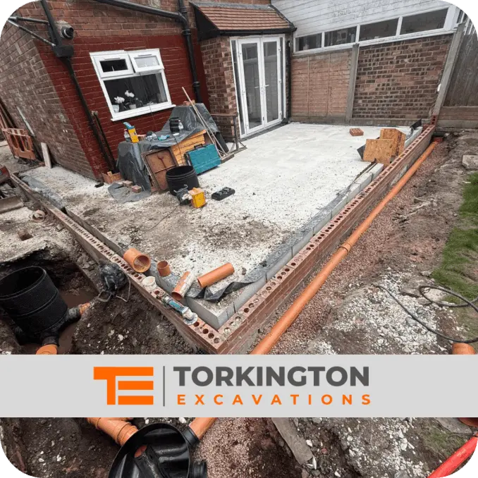 Drainage trench being dug with exposed pipework installation